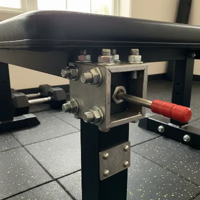 DIY leg developer attachment on a weight bench, showcasing the secure connection point with bolts and a locking pin.