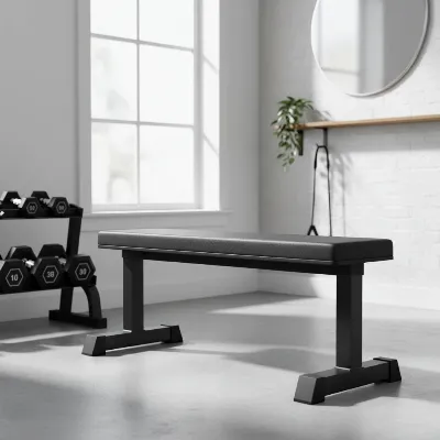 A sturdy flat utility weight bench in a minimalist home gym setting with dumbbells.
