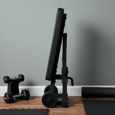 REP Fitness AB-5200 adjustable weight bench stored vertically in a compact home gym setting.